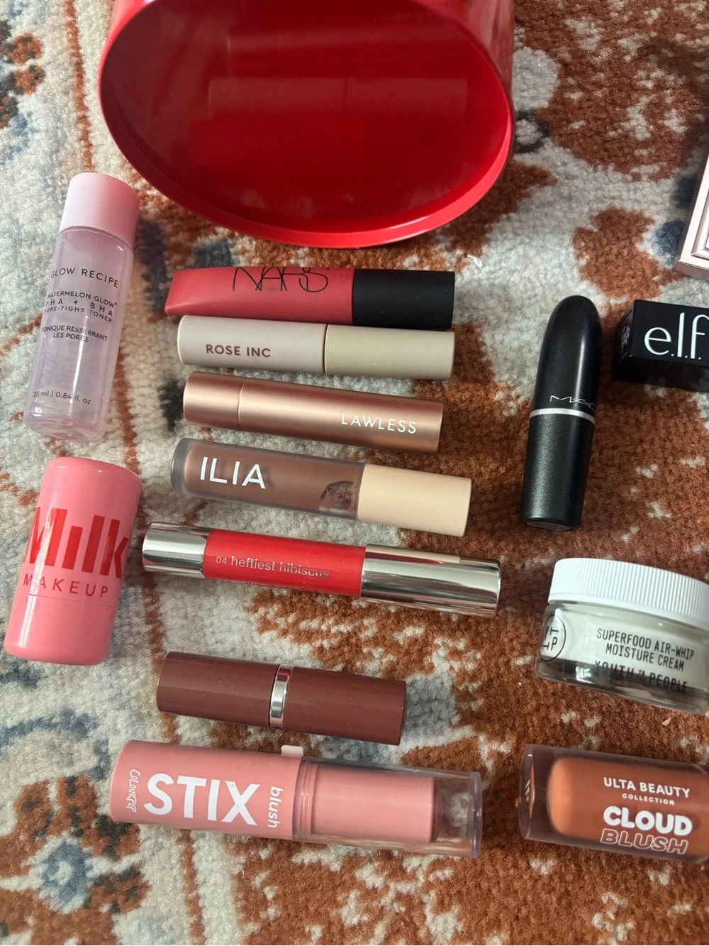 Glossier red mini bucket with mixed pink and mauve lip products